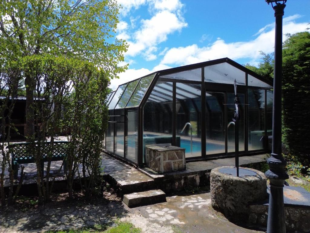 a glass house with a pool inside of it at Casa Rural Los Ciegos in Peguerinos