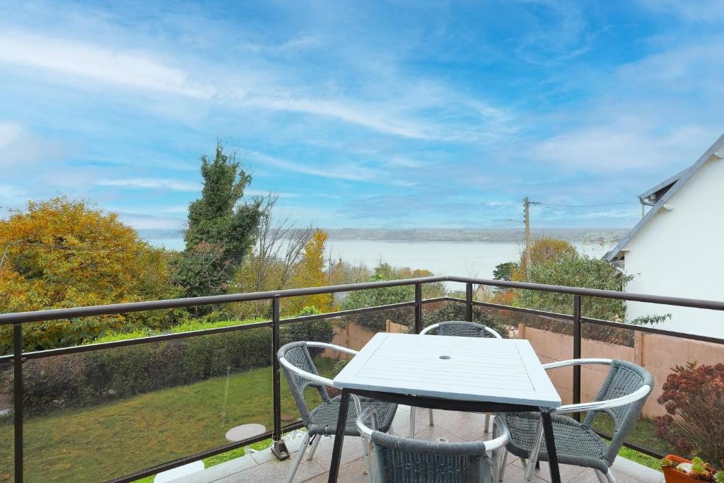 a table and chairs on a balcony with a view at Bellevue rue de la petite corniche in Perros-Guirec
