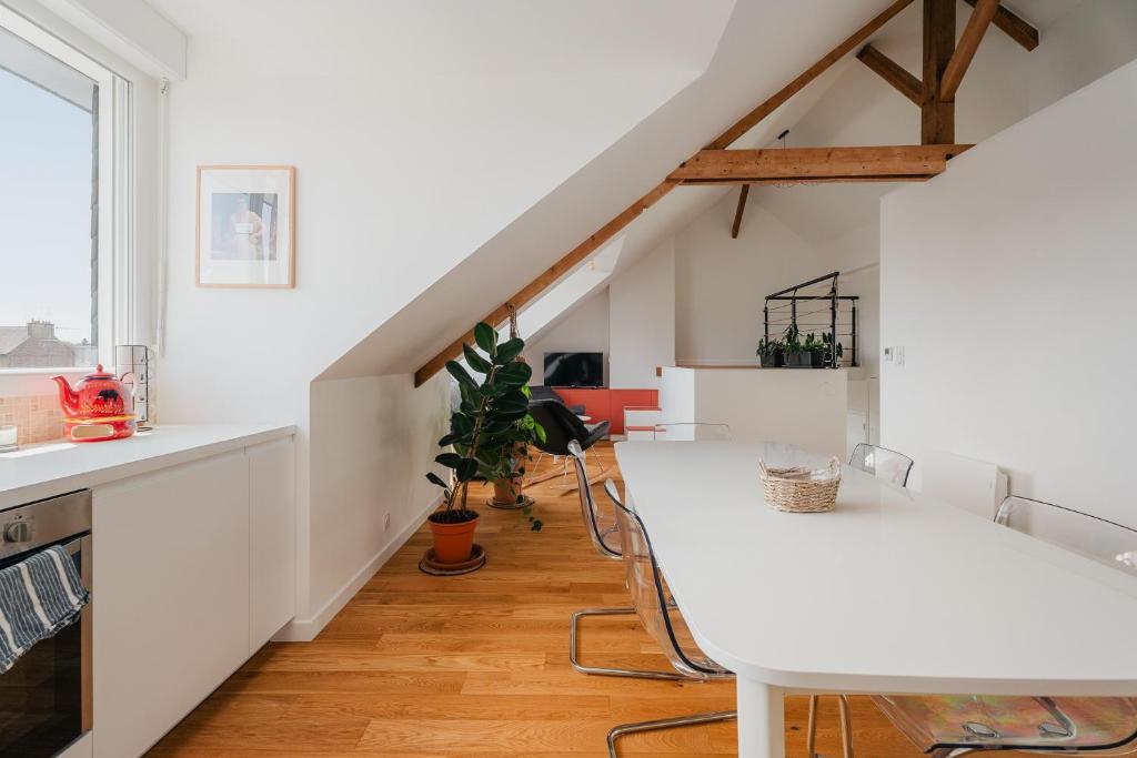 a kitchen with white counters and a white table at Logement calme proche centre ville in Rennes