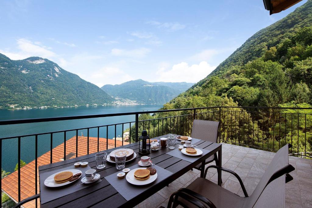 a table on a balcony with a view of a lake at Appartamento 5 Il Tornante in Nesso