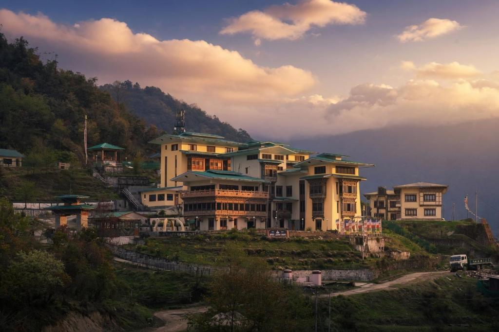 a group of houses on top of a hill at Norbu Lingka Resort in Tongsa