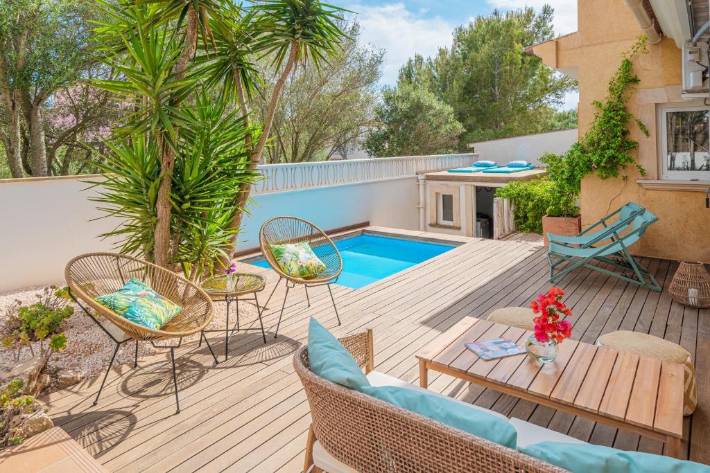 a patio with chairs and a swimming pool at Villa Bahia Azul in Llucmajor