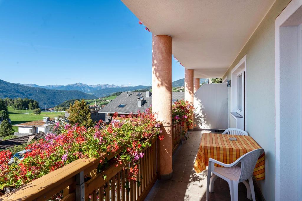 a balcony with flowers and a table and chairs at Residence Diana Apartment 202 in Terento