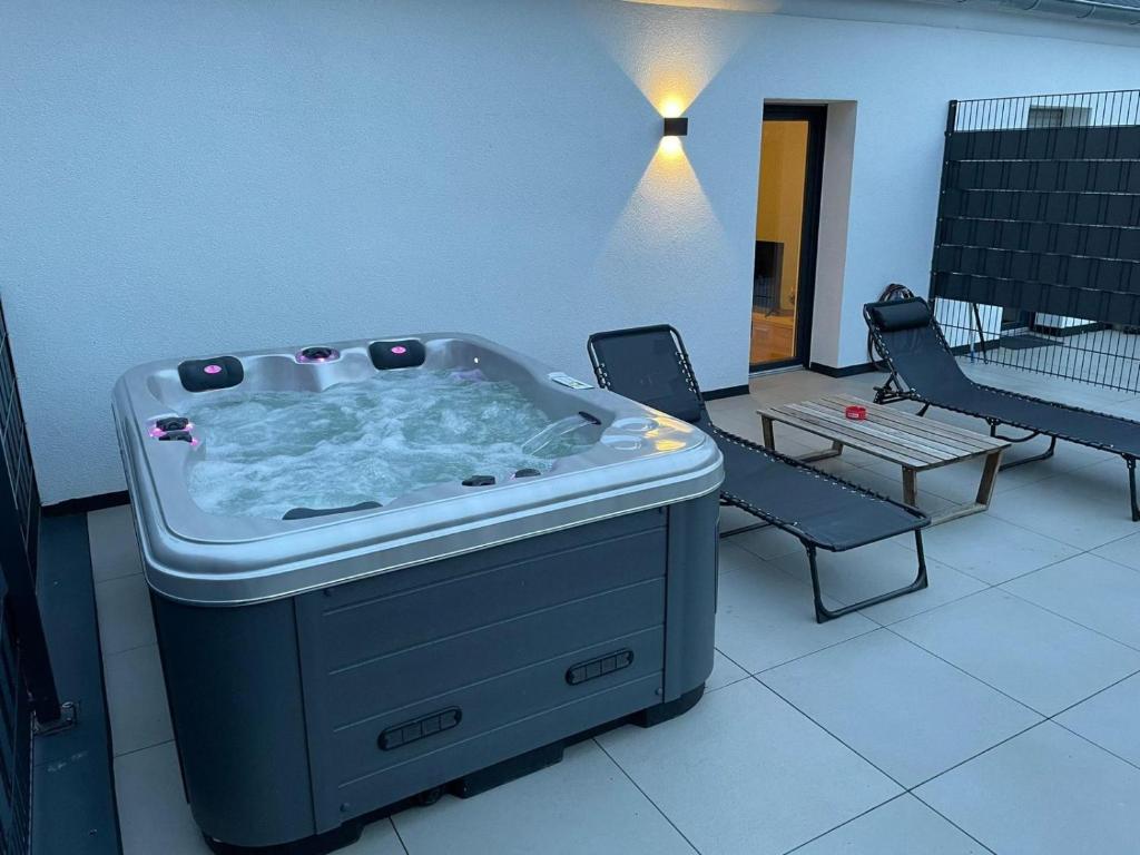 a hot tub in a room with a table and a bench at Apartment mit Jacuzzi Enschede 10km in Gronau