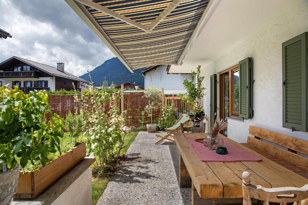 a patio with a wooden table and benches at Ferienwohnung Pfingstrose in Garmisch-Partenkirchen