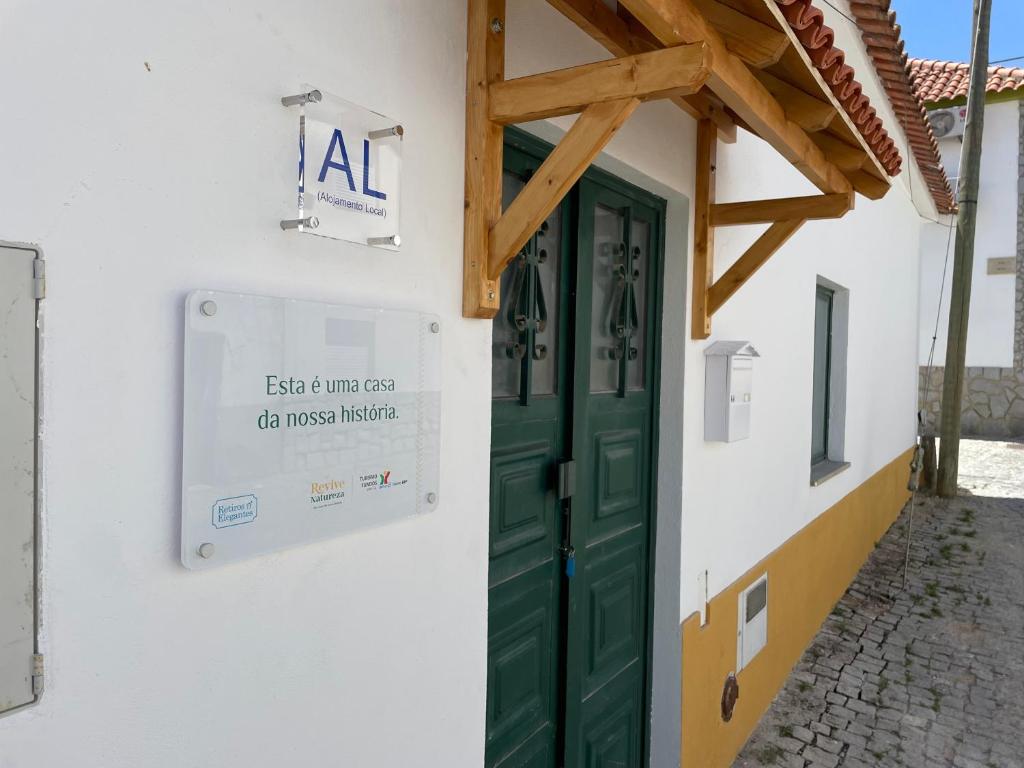 a building with a green door and a sign on it at Retiro Do Tejo in Malpica