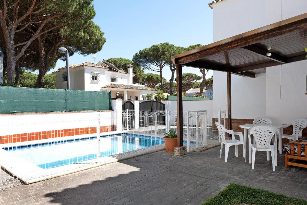 a patio with a table and chairs next to a swimming pool at Poniente in Roche