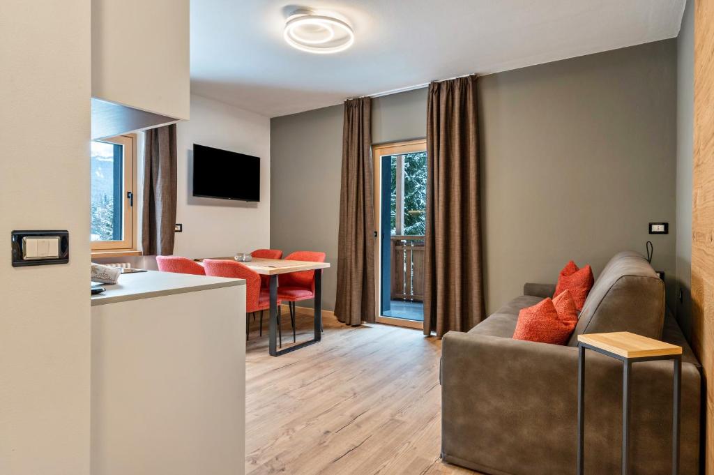 a living room with a couch and a table at Kamerloy Apartments B in Campitello di Fassa