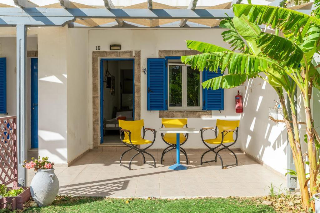 a patio with yellow chairs and a table at Perasma Studios 10 in Kipri