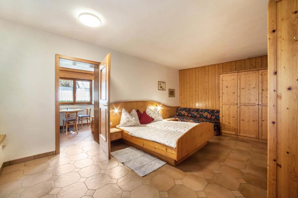 a bedroom with a bed and a table in a room at Camping Passeier Löwenzahn in Saltusio