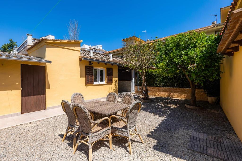 a wooden table and chairs in front of a house at Can Juanito in Alcudia