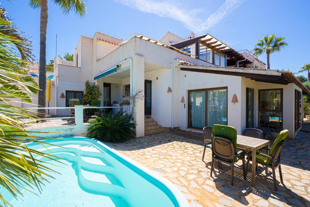 a house with a table and chairs next to a swimming pool at Casa Colina in Albir
