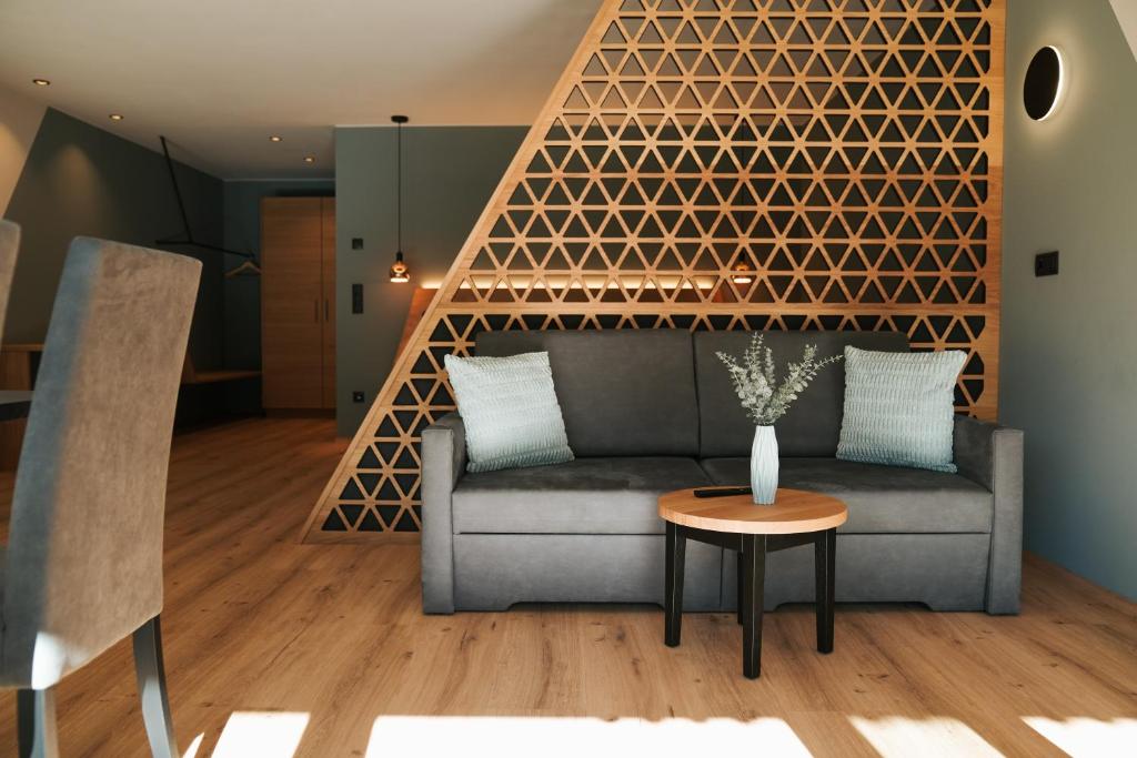 a living room with a couch and a table at Aktiv Lodge Meran - Garden One in San Martino