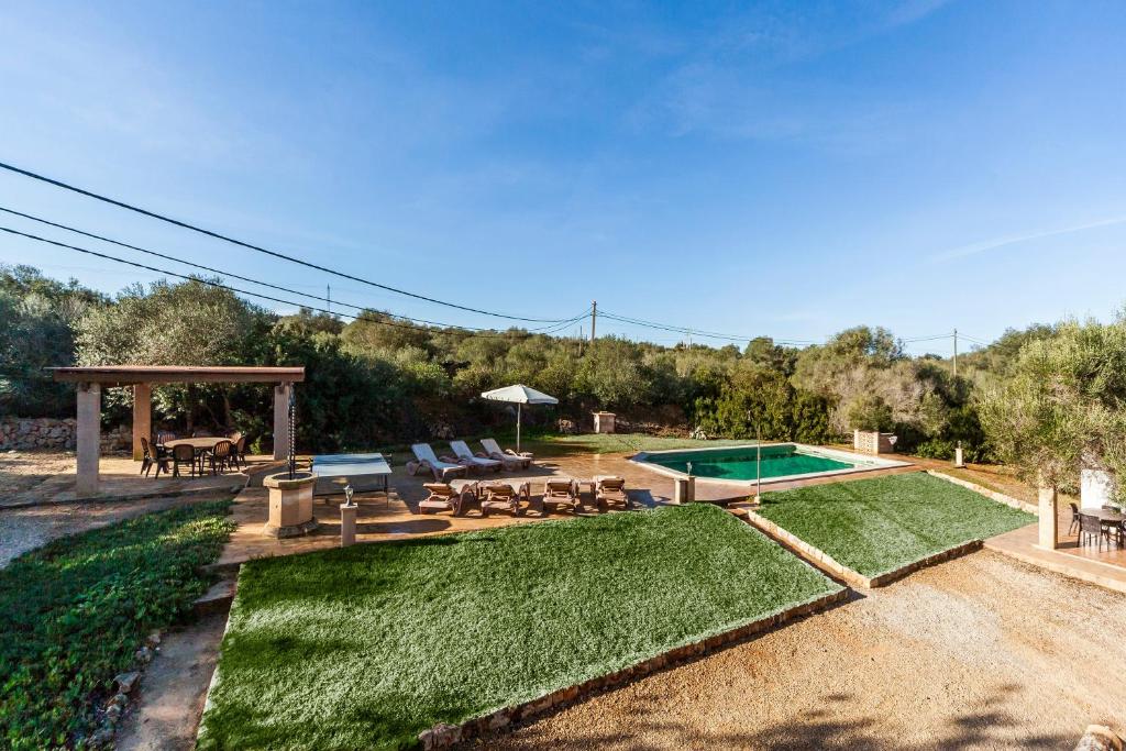 a backyard with a swimming pool and a picnic table and a picnic table at Es Figueral in Campos