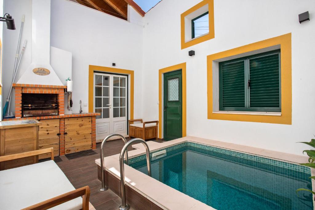 a swimming pool in a house with a kitchen and a fireplace at Casa Valada My Land in Valada