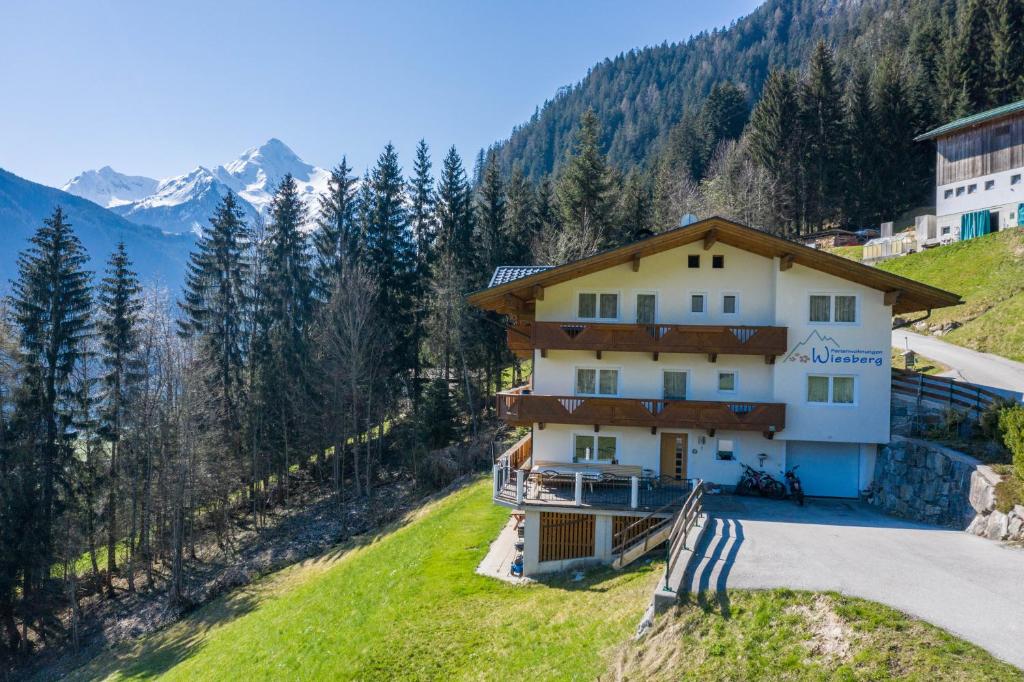 a house on a hill with mountains in the background at Ferienwohnung Jakob in Schwendau