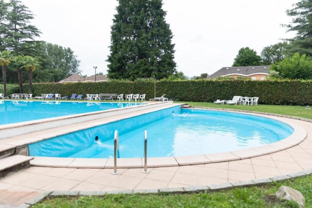 a large swimming pool with chairs in a yard at Nice Lake view apartment in Ispra
