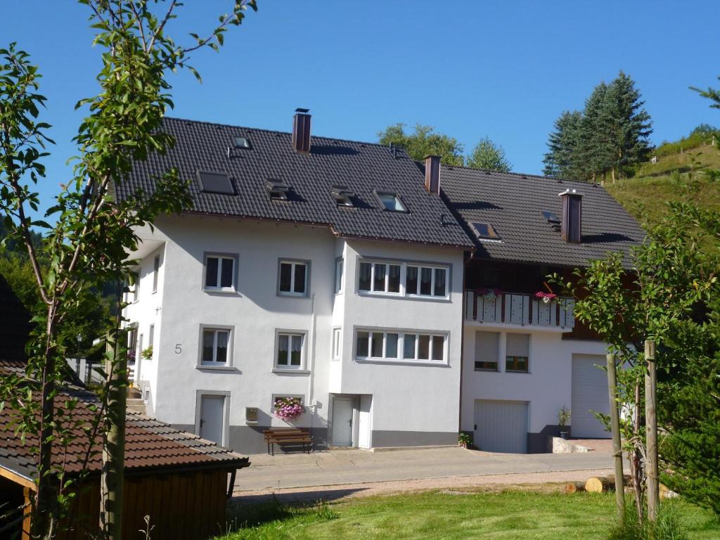 a large white building with a black roof at Ferienwohnung am Geißberg in Kleines Wiesental
