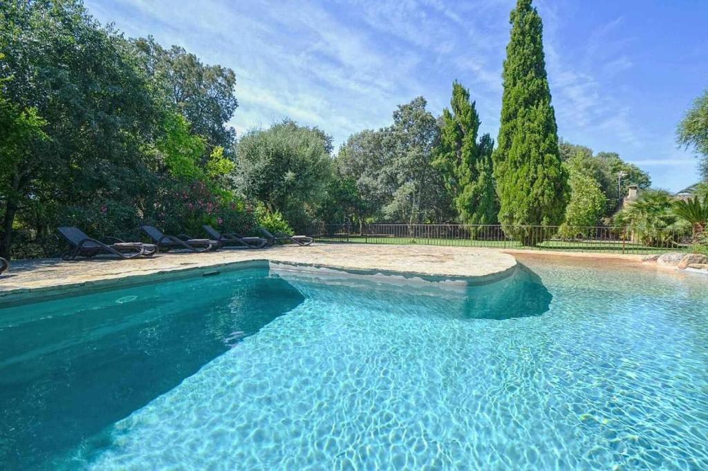 a swimming pool in a yard with trees at Sestadors in La Puebla