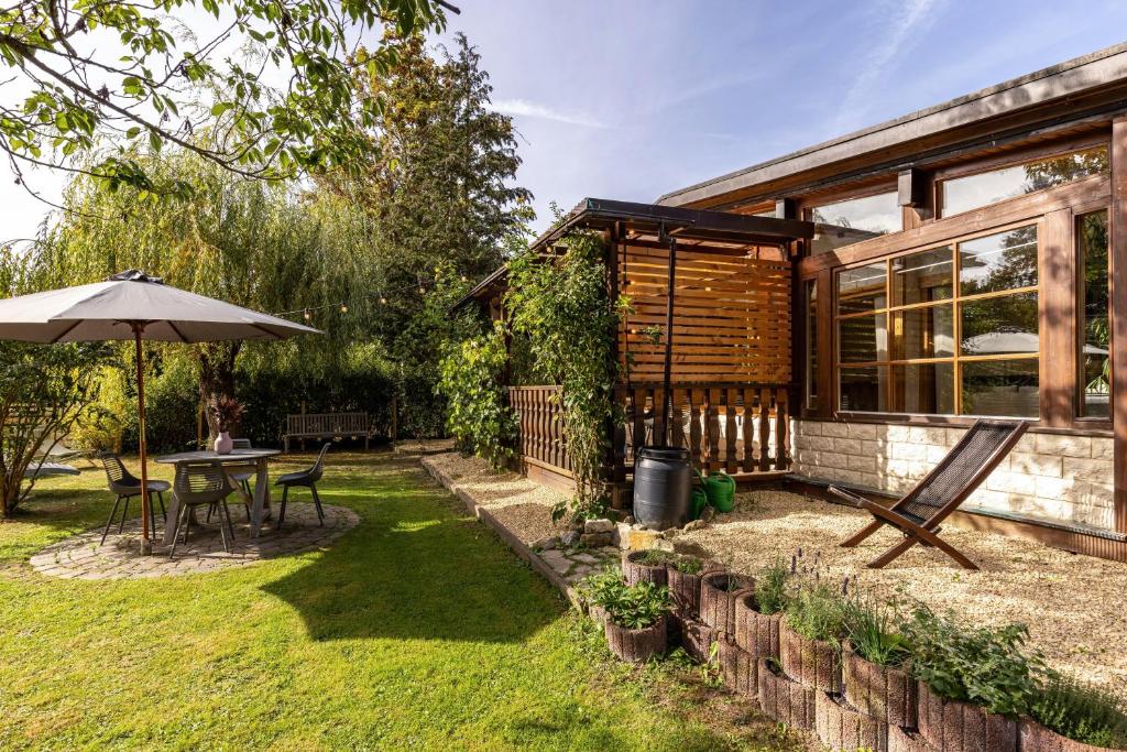 a house with a table and an umbrella in the yard at La Casa Holzwiesen in Starzach