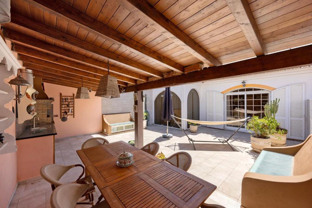 a patio with a wooden table and chairs at Villa Ramos in Lagos