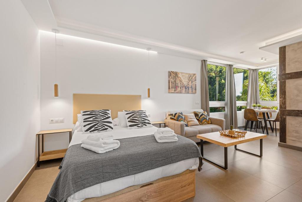 a bedroom with a large bed and a living room at Manuela's whim in Málaga