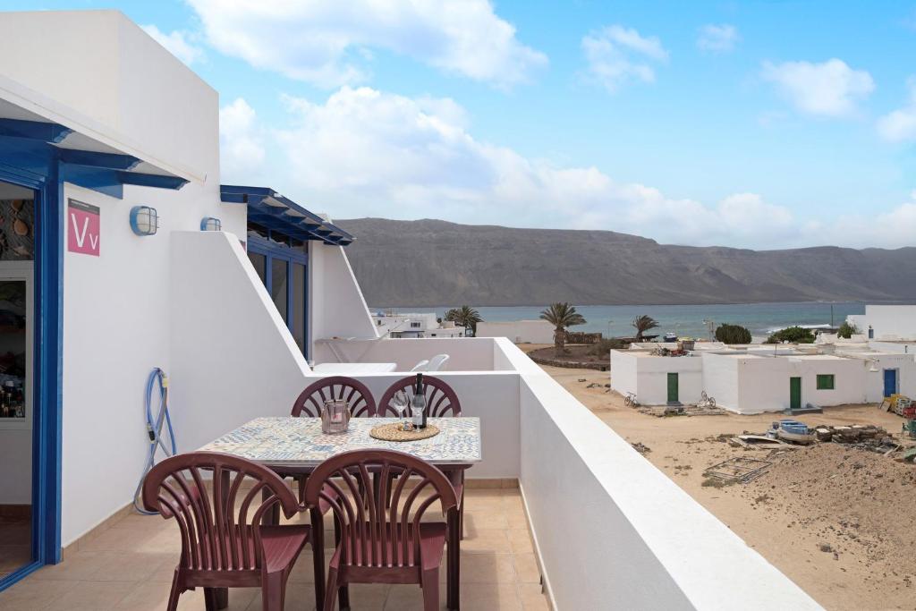 a table and chairs on a balcony with a view of the ocean at Vista al Mar, La Graciosa in Caleta de Sebo