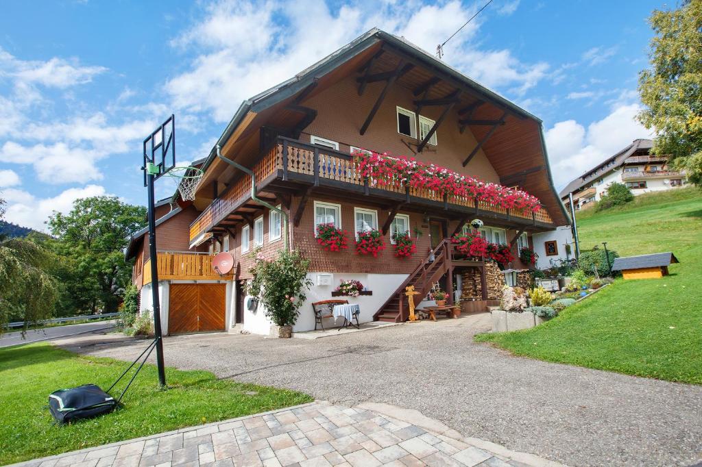 a house with red flowers on the balcony at Gästehaus Klingele in Todtmoos
