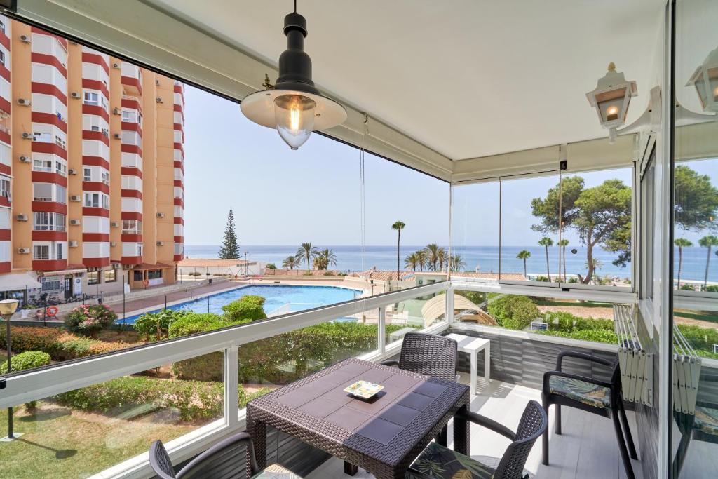 a balcony with a table and chairs and a view of the ocean at Primera línea con terraza A104 in Torrox