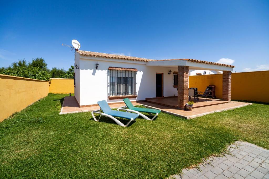 ein Hof mit zwei Stühlen und einem Haus in der Unterkunft Luisa 1 in Conil de la Frontera