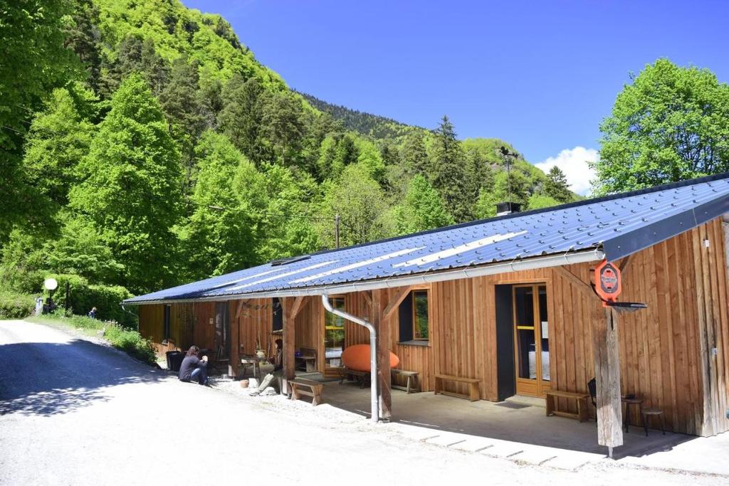 a small wooden building with a solar roof at Maison Skioura, Gite De Groupe in Luchon