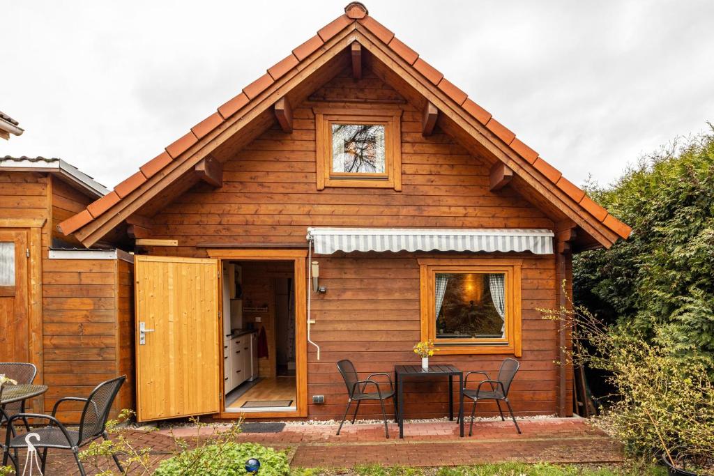 a cabin with a table and chairs in front of it at Hütte im Heidekreis in Lindwedel