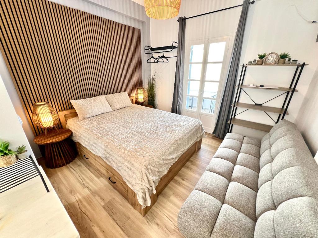 a bedroom with a bed and a couch at aeolian blu 6 in Parikia