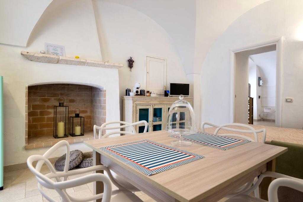 a dining room with a table and chairs and a fireplace at Arco Antelmy in Ceglie Messapica