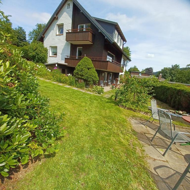 a house with a lawn and two chairs in front of it at Ferienhaus Hahnenklee in Goslar