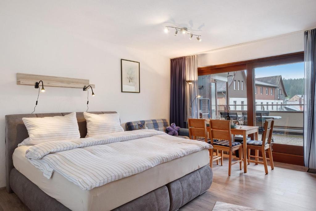 a bedroom with a bed and a dining room with a table at Schwarzwaldliebe mit Pool, Sauna in Schönwald