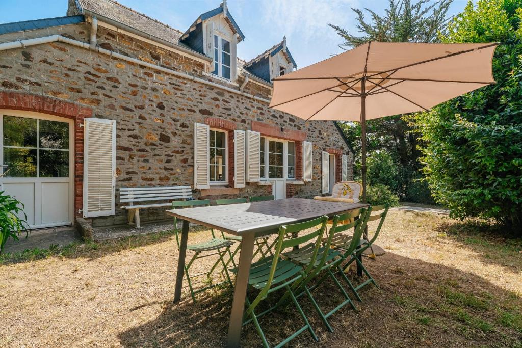 a wooden table and chairs with an umbrella at Maison Pleneuf Val André Plage 5min in Pléneuf-Val-André