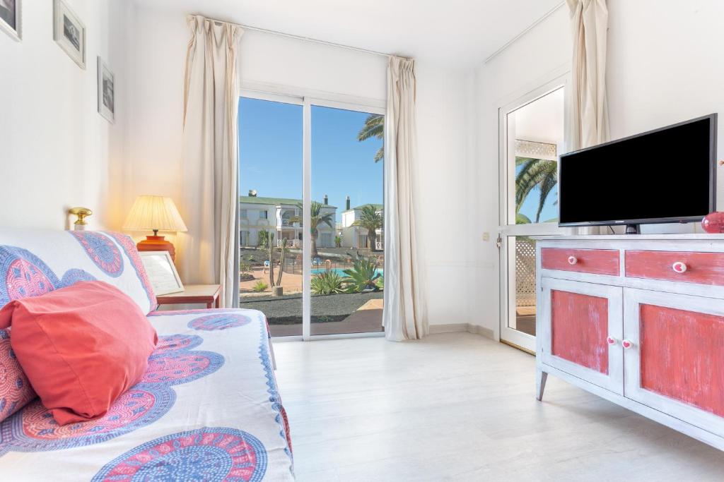 a living room with a flat screen tv and a couch at Relax Holidays Corralejo in Corralejo
