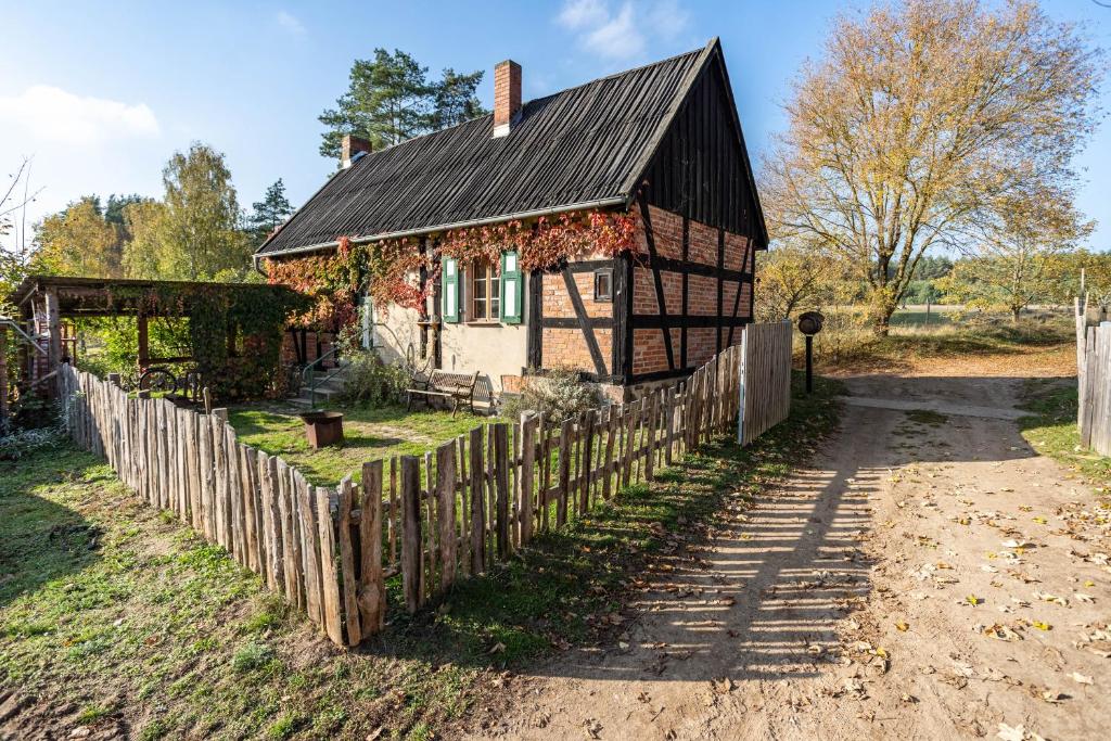 an old house with a fence in front of it at Casa del Sol - Fachwerkhäuschen in Lychen