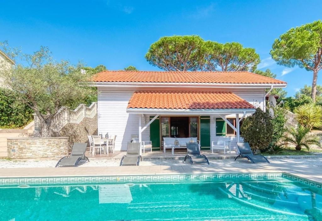 a villa with a swimming pool and a house at Costacabana - Villa Primadonna in Lloret de Mar