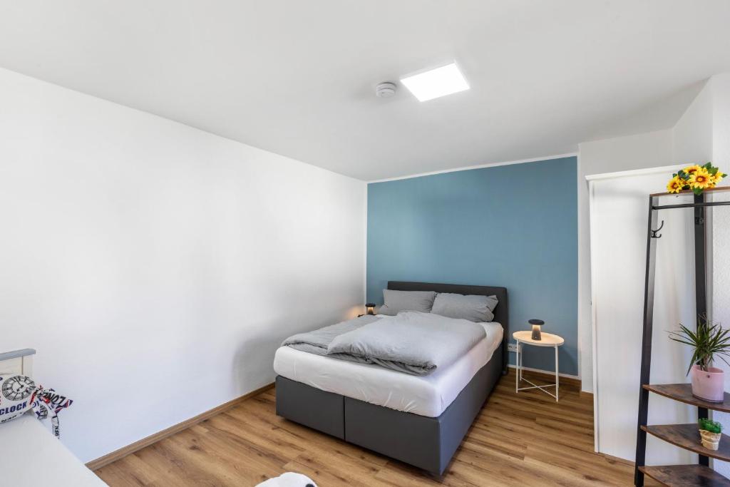 a bedroom with a bed and a blue wall at Pr-Ferienwohnung in Stierstadt