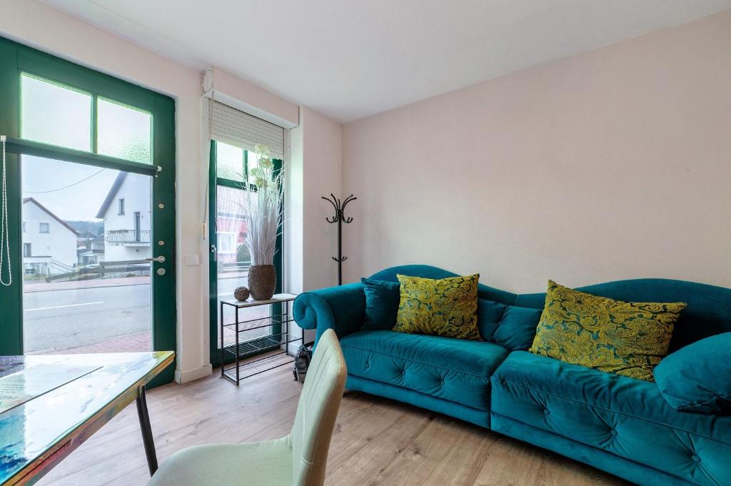 a living room with a blue couch and a table at Gemütliche Wohnung in Reimsbach in Beckingen