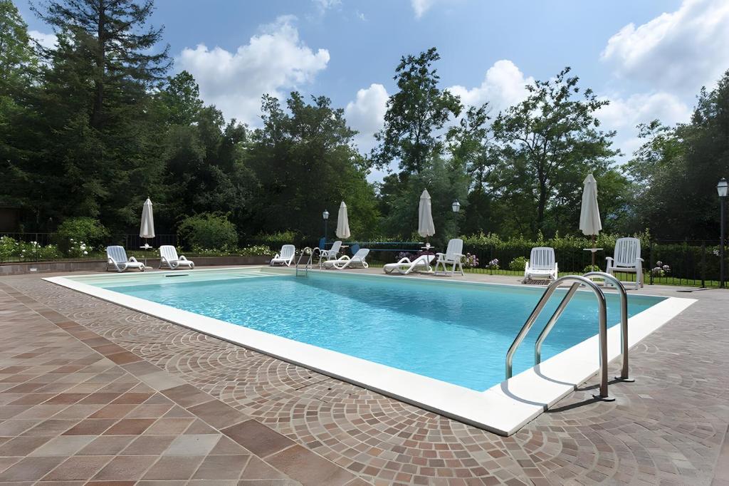 a swimming pool with chairs and a slide in a yard at All Inclusive Villa Con Piscina in Camaiore