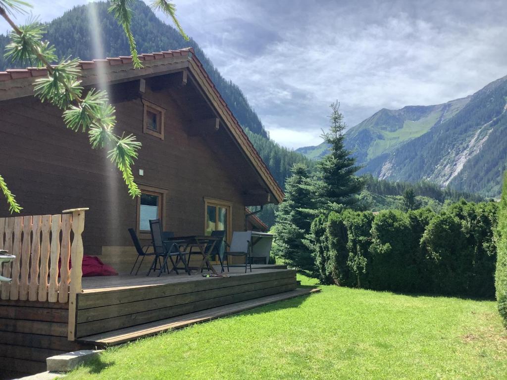 a house with a deck with a table and chairs at Chalet Finkennest in Neukirchen am Großvenediger