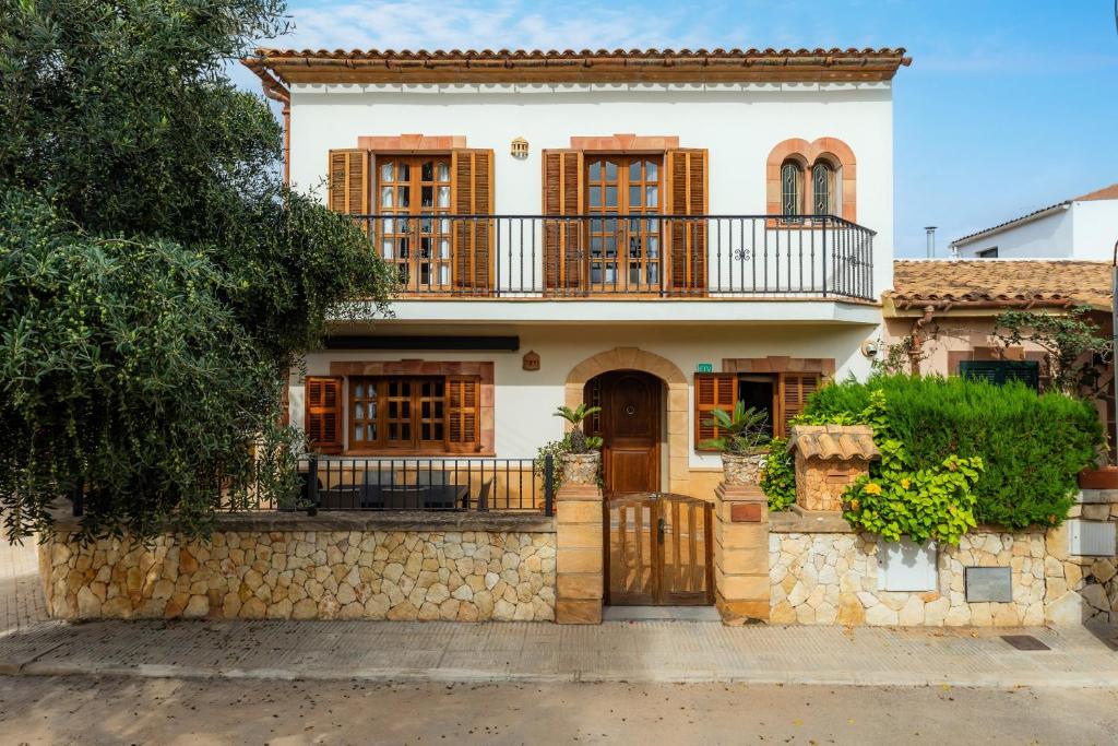 a house with a balcony on a stone wall at Sa Fonteta Cala Morlanda in S'Illot