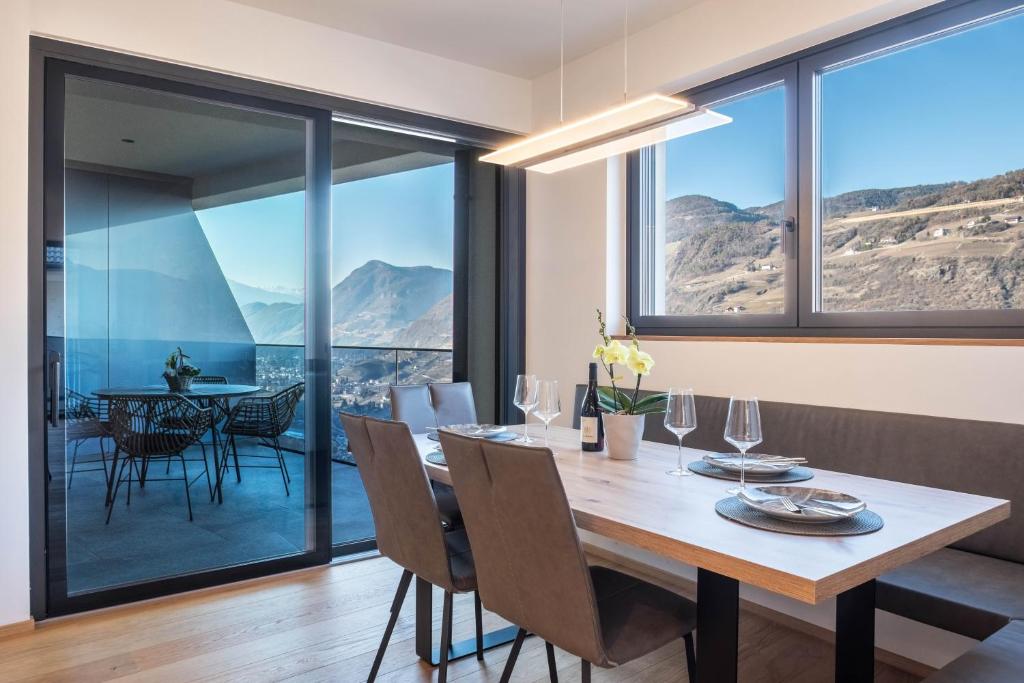 a dining room with a table and chairs and glass windows at Falsers Mountain Lodge in Cornedo all'Isarco