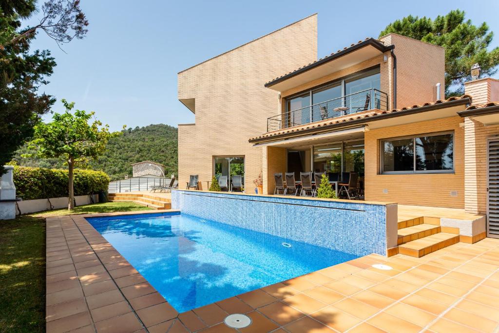 a house with a swimming pool in front of a house at Exclusive Villa with pool seaview in Tossa de Mar