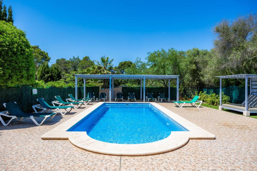 a swimming pool with chairs and a gazebo at Villa Can Neo in Santanyi