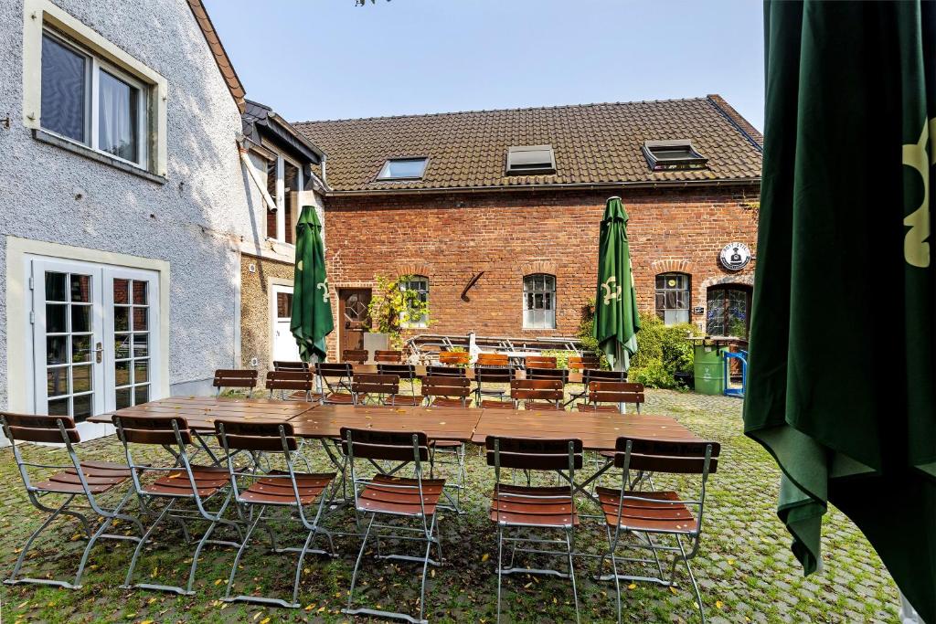 a wooden table and chairs in front of a building at Modernes Loft mitten im Grünen in Neukirchen-Vluyn