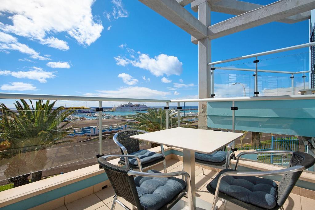 a table and chairs on a balcony with a view of the ocean at Casa Mar y Luz in Morro del Jable